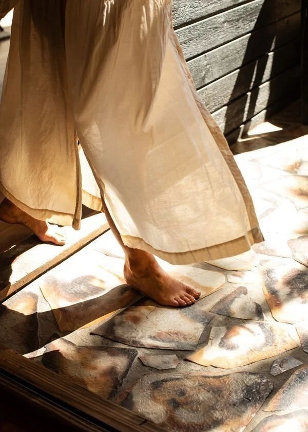 Guest in linen trousers walking barefoot