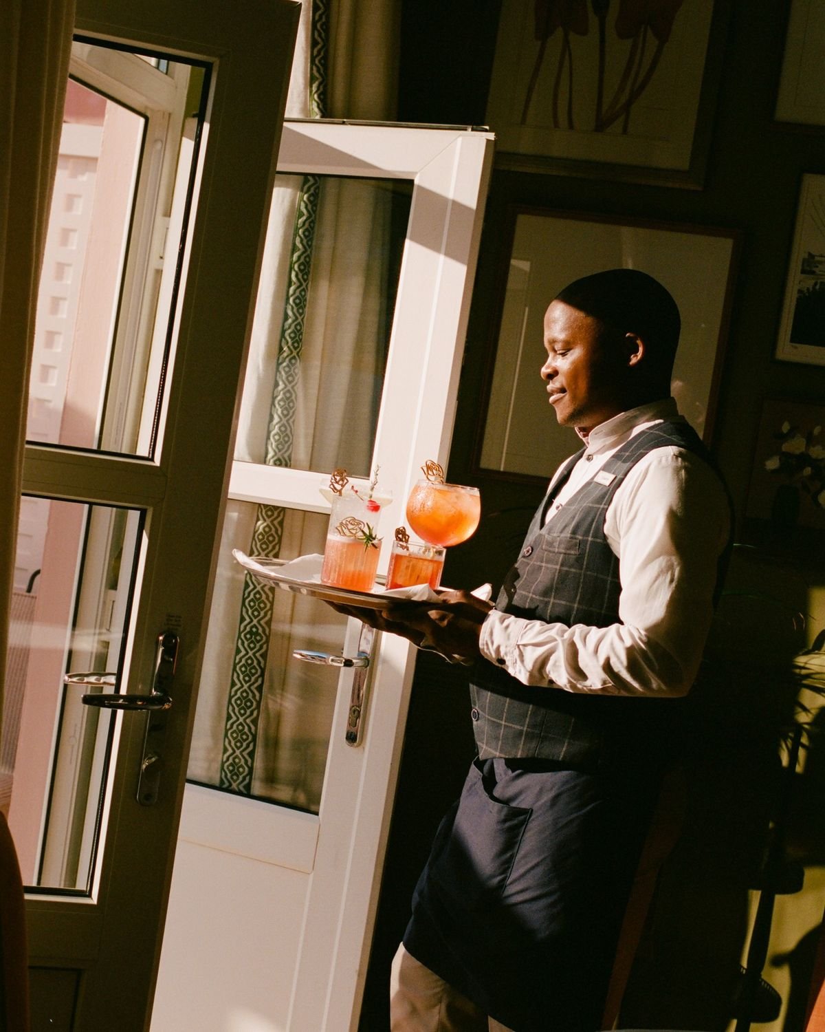 Host serving drinks on a tray at SOMA Franschhoek