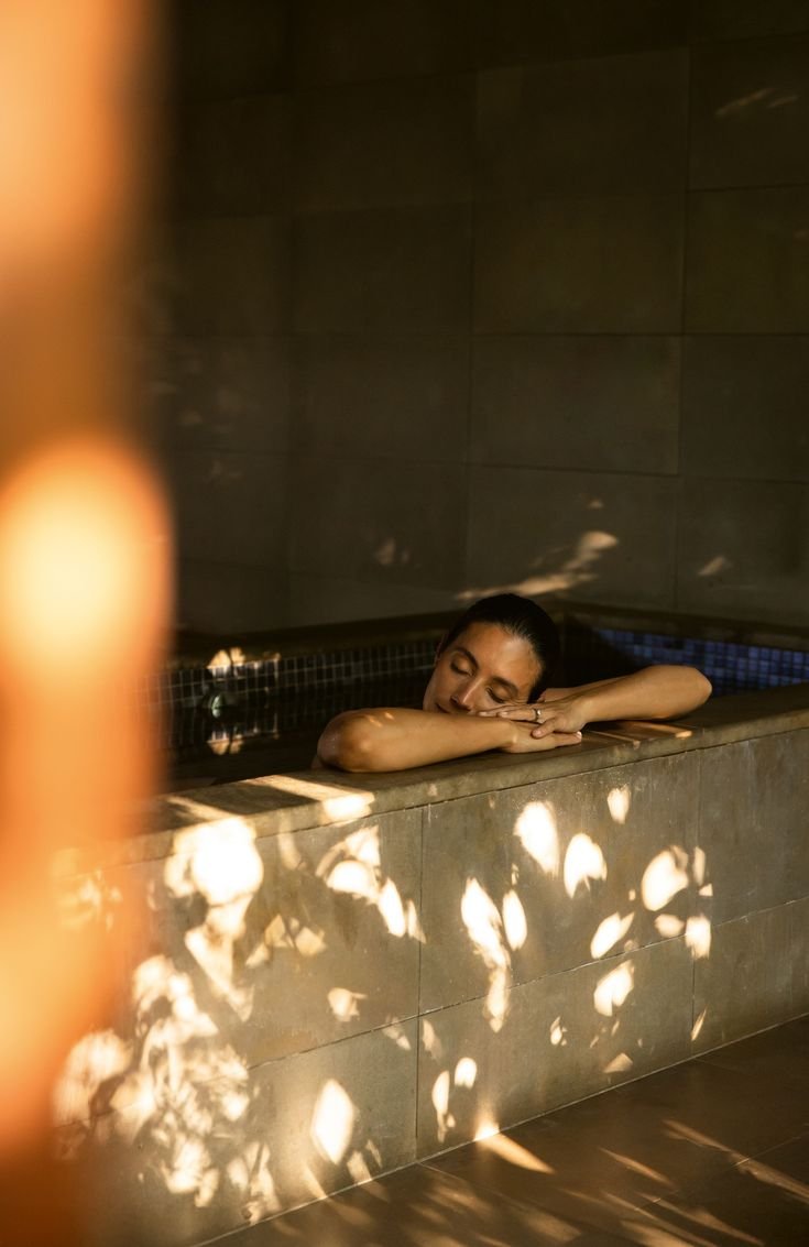 Guest relaxing in a candlelit bath at SOMA